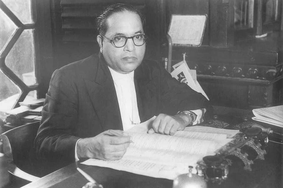 Photograph of Dr. B. R. Ambedkar holding the Constitution of India in 1950